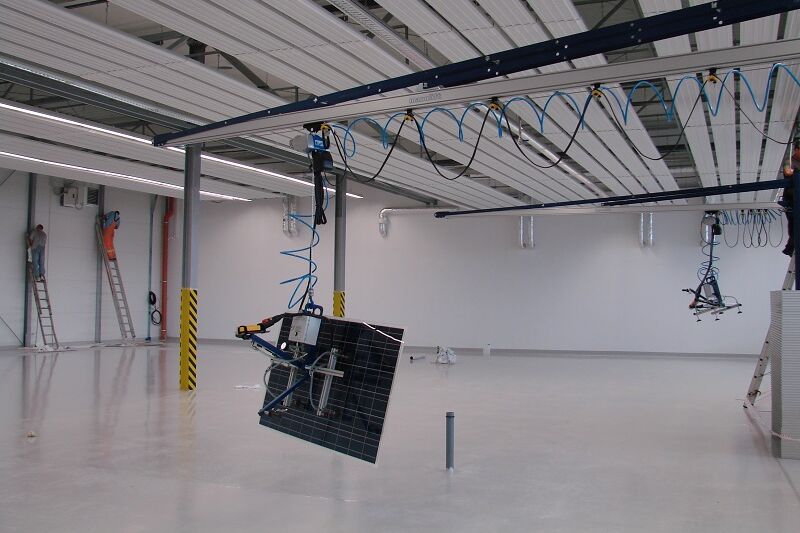 Solarmodul fliegt in der Produktionshalle an einem Vakuumheber der Firma AERO-LIFT