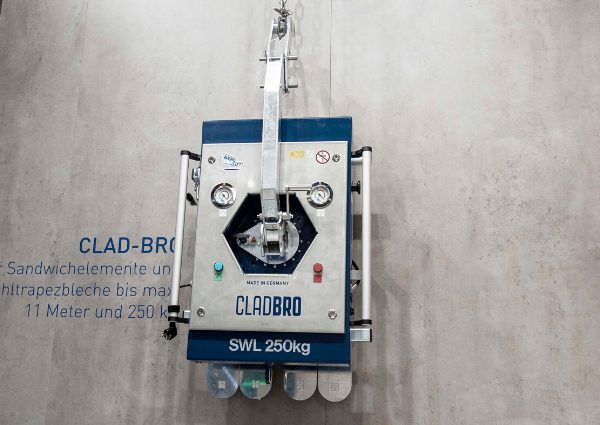 Compact panel lifter for construction site CLAD-BRO in front view in front of gray concrete wall