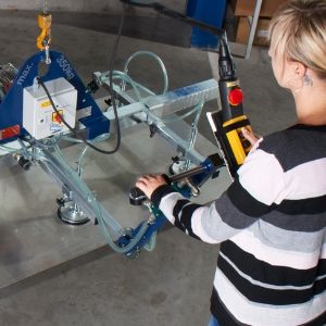 Woman controls a vacuum lifter with the manipulation handle