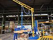Mobile crane in operation transporting pallets with the help of a vacuum lifter