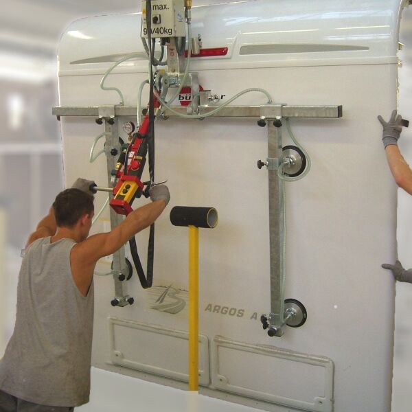 Man operates vacuum lifter vertically to lift a caravan side panel