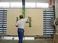 Mann bedient Vakuumheber der Firma AERO-LIFT in der Holzbranche zum Heben von Holzplatten in der Werkstatt