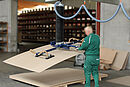 Mann bedient Vakuumheber der Firma AERO-LIFT in der Holzbranche zum Heben von Holzplatten in der Werkstatt