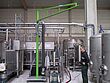 Man operating vacuum lifter on a mobile crane in a production facility