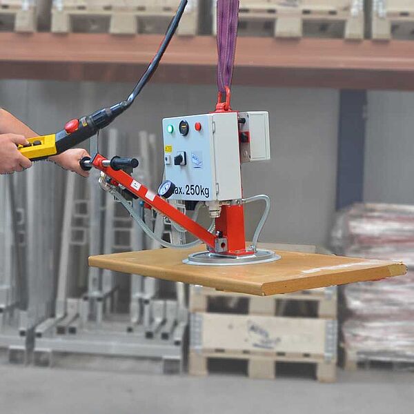 Mains independent battery operated vacuum lifter transports a board in a workshop
