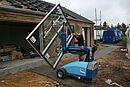 Man operating mobile vacuum lifting device CLAD-LIFT 350 in outdoor area while inserting a glass pane