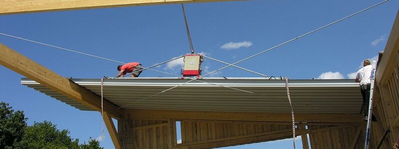 The vacuum lifter CLAD-BOY in use for lifting roof panels on the construction site.