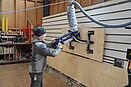 Mann bedient MAXI-LIFT bei einer Holz Beschickungsanlage in einer Produktinosstaette