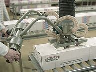Person operating handle of hose lifter in a production hall