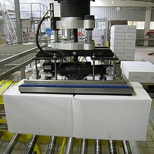 Area gripper lifts two cartons in a production hall