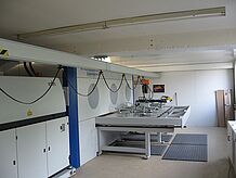 Krank- und Schienensystem mit Vakuumheber und Metallplatte in einer Produktionshalle