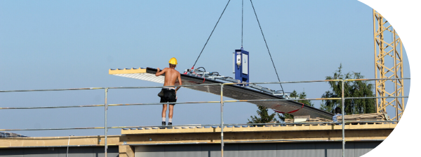 Man operates CLAD-MAN vacuum lifter on construction site for panels on roof and wall